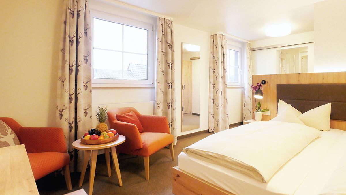 Doppelzimmer NaturPur Bett, Sitzbereich und TV mit Ausblick