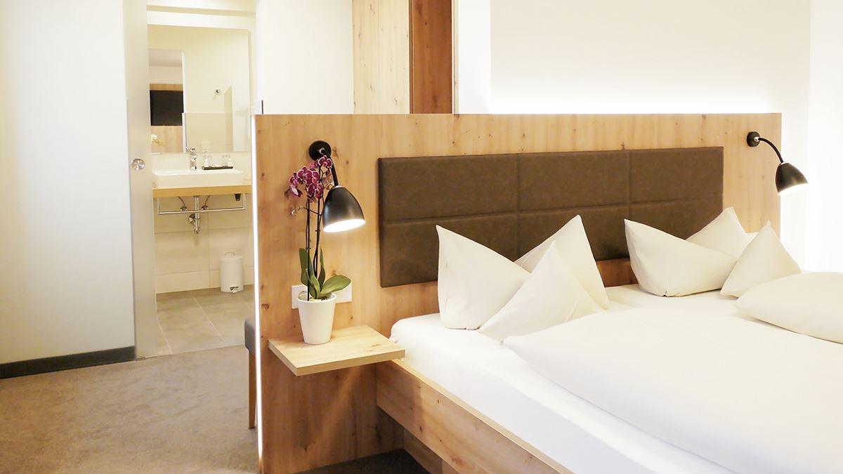 Doppelzimmer NaturPur Bett mit Blick ins Bad