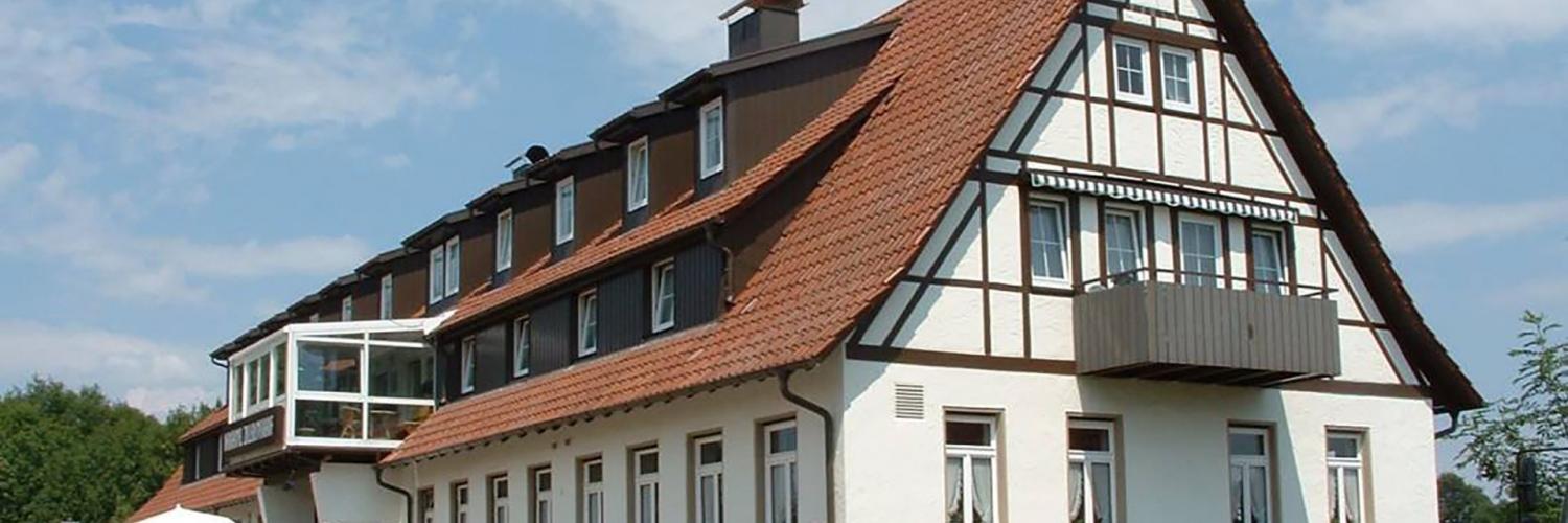 Die Vorderansicht des Zollersteighofs, blauer Himmel mit leichten Quellwolken